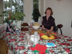 Glenda sitting by the buffet table at her Book Arrival Celebration