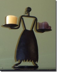 Stylized woman balancing two candles - made in black metal